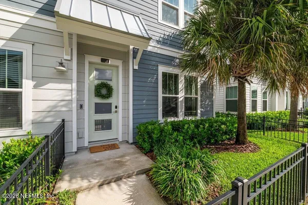 a view of a house with a yard and potted plants