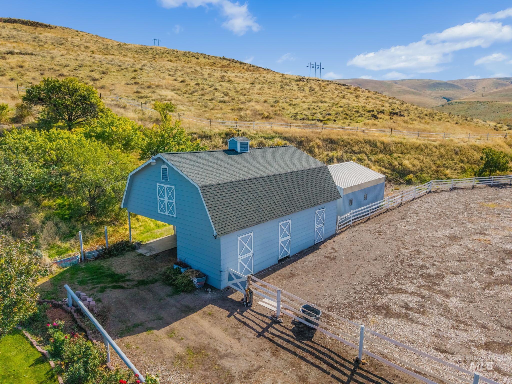 531 Silcott Road Clarkston, WA 99403 - Photo 5 of 43 Barn structure with a gambrel roof, light blue siding, and white trim accents