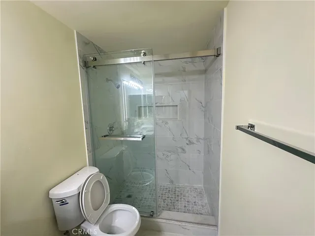 a bathroom with a granite countertop shower a toilet and a sink