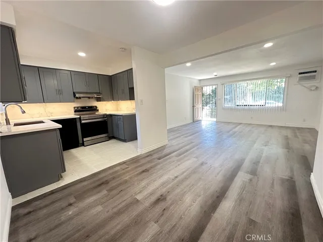 a kitchen with kitchen island wooden floors and stainless steel appliances