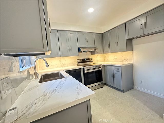 a kitchen with a sink a stove and a refrigerator