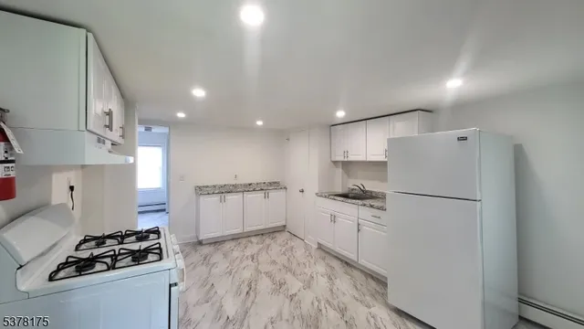 a kitchen with a refrigerator and a stove top oven