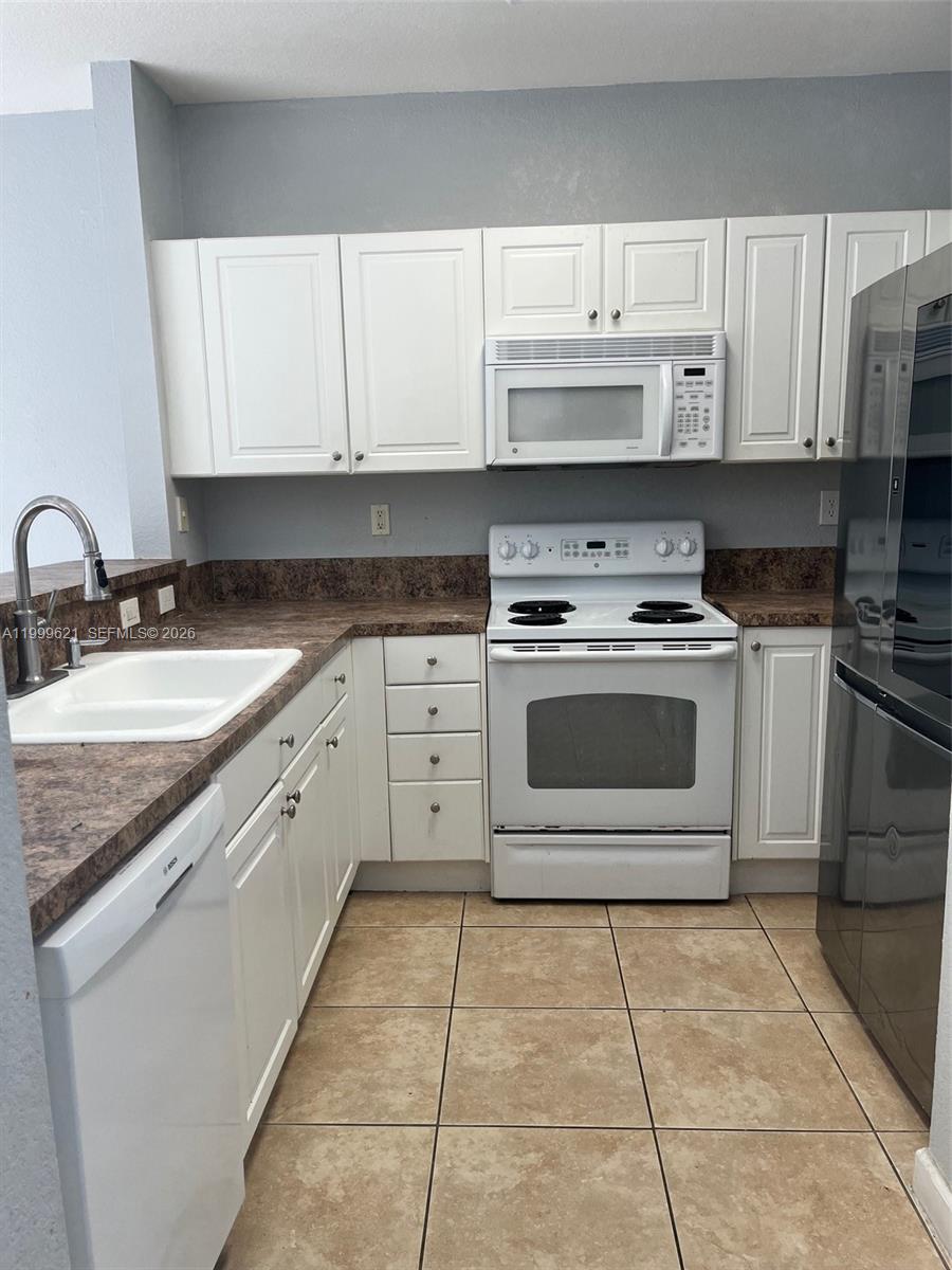 1650 Northeast 33rd Road, Unit 10610 Homestead, FL 33033 - Photo 6 of 22 a kitchen with cabinets appliances and a sink