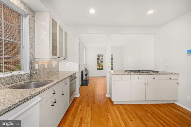 a spacious bathroom with a granite countertop sink a mirror and a bathtub