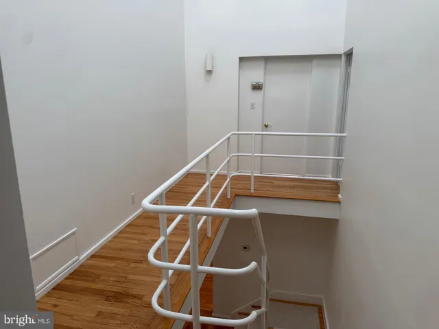 a room with wooden floor and white walls
