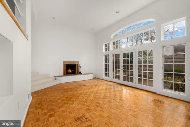 a large white bed in a room next to a window