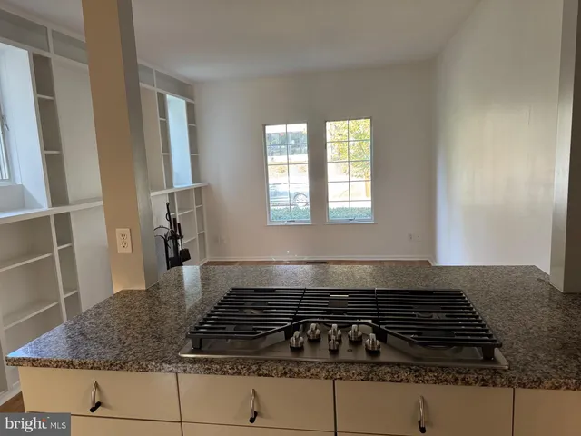 a kitchen with granite countertop a stove and white cabinets