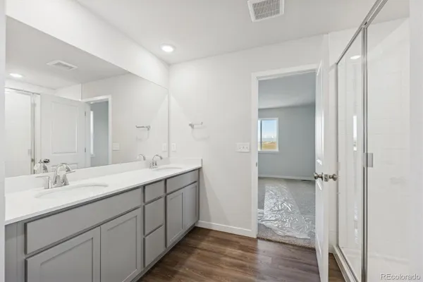 a spacious bathroom with a double vanity sink and mirror