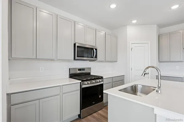 a kitchen with white cabinets sink and stainless steel appliances