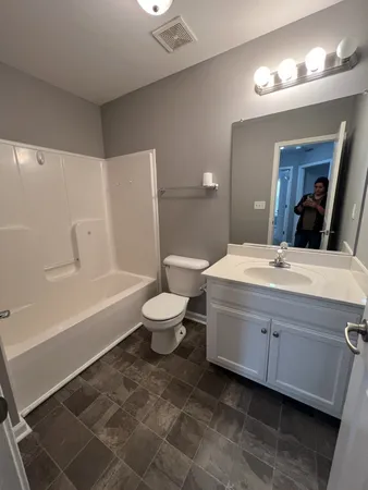 a bathroom with a double vanity sink mirror and toilet