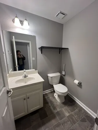 a bathroom with a toilet sink and mirror