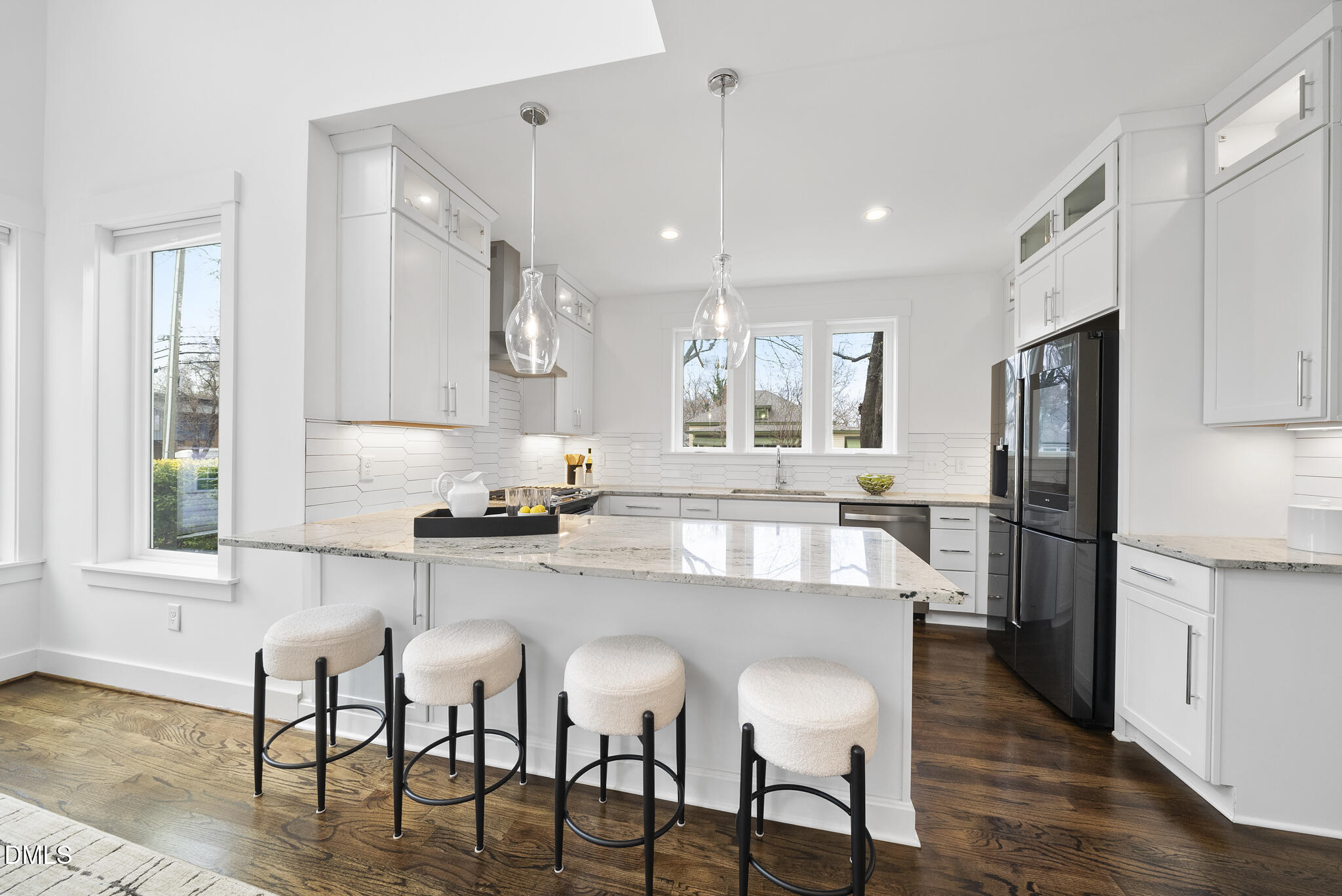200 Bledsoe Avenue Raleigh, NC 27601 - Photo 7 of 42 a kitchen with stainless steel appliances granite countertop a stove a refrigerator a microwave oven with a dining table and chairs