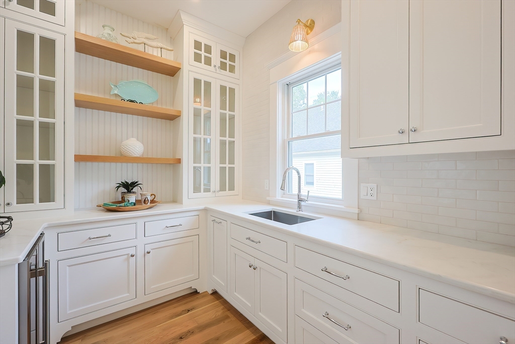28 Quaker Run Road Mashpee, MA 02649 - Photo 7 of 42 a kitchen with white cabinets and a window