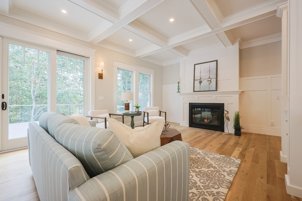 28 Quaker Run Road Mashpee, MA 02649 - Photo 9 of 42 a living room with furniture a large window and a fireplace
