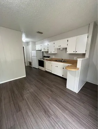 a large kitchen with a wooden floor and stainless steel appliances