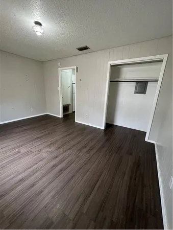 a view of empty room with wooden floor
