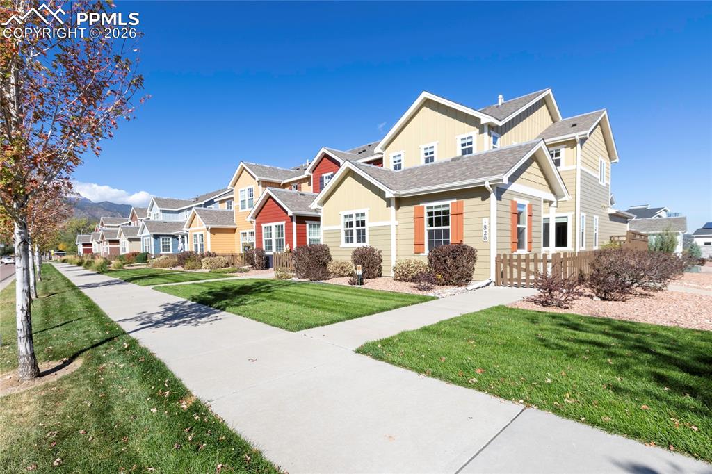 1820 Lower Gold Camp Road Colorado Springs, CO 80905 - Photo 26 of 27 a view of a white house next to a yard with big trees