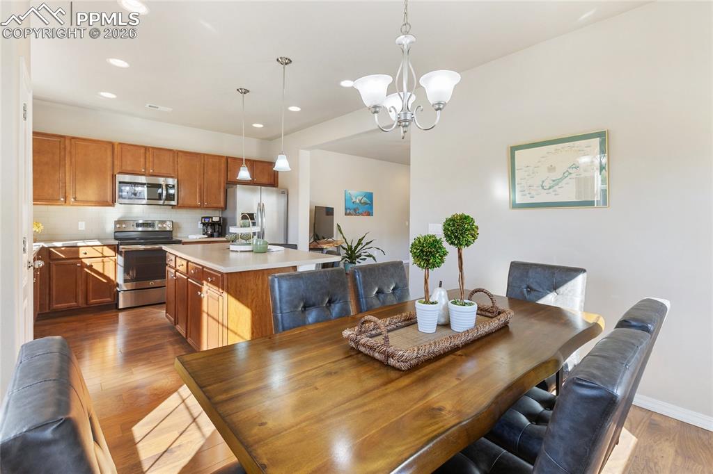 1820 Lower Gold Camp Road Colorado Springs, CO 80905 - Photo 8 of 27 a view of a dining room with furniture a chandelier and wooden floor