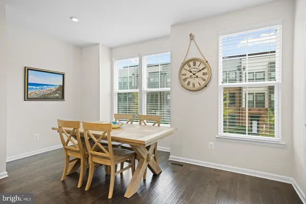 a dining room with wooden floor a glass table and a window