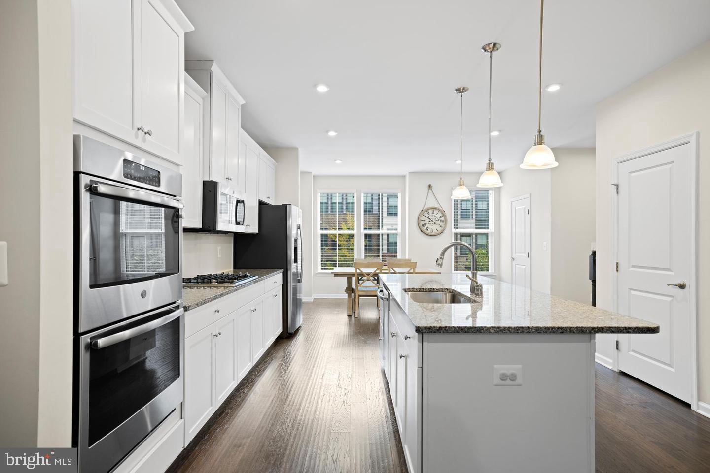 22255 Sims Terrace Ashburn, VA 20148 - Photo 16 of 27 a kitchen with kitchen island granite countertop a stove a sink a refrigerator and white cabinets with wooden floor