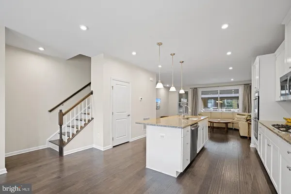 a large white kitchen with a large counter top appliances and cabinets