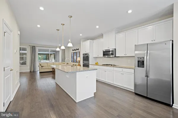 a kitchen with counter top space a sink cabinets and stainless steel appliances