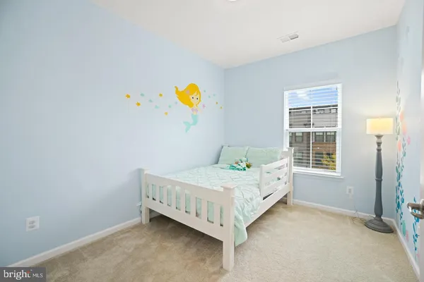 a bed sitting in a bedroom next to a window