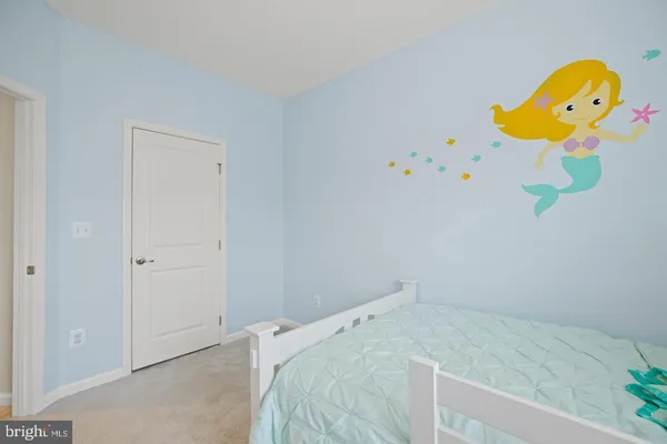 a bedroom with a bed and painting on the wall