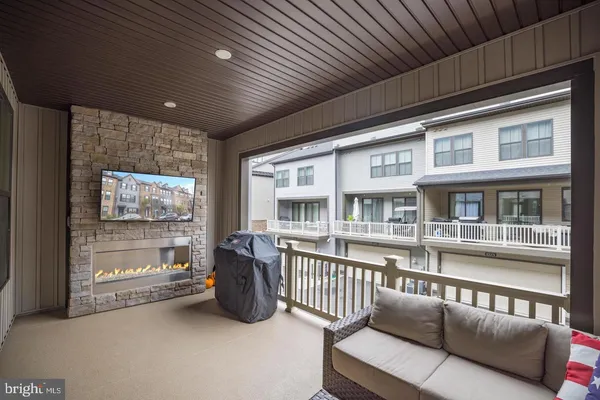 a view of a deck with couches chairs and wooden floor