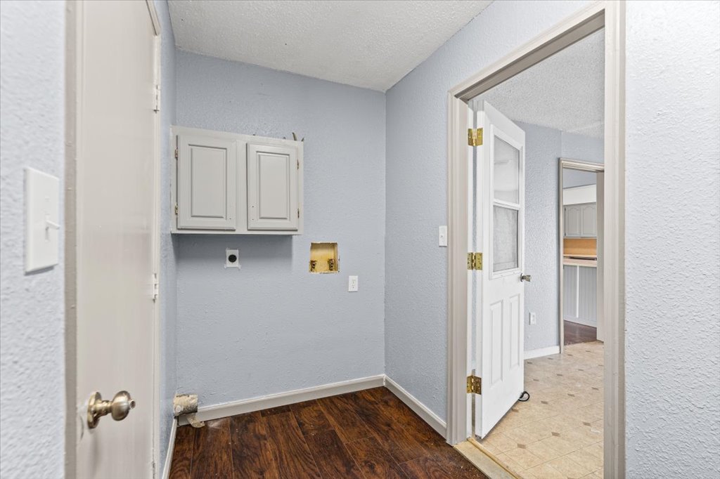 650 West Austin Street Luling, TX 78648 - Photo 10 of 18 Functional utility space with durable wood-look flooring and built-in cabinetry for organized living.