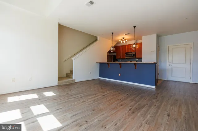 a kitchen with stainless steel appliances granite countertop a sink dishwasher a stove top oven a clock and a potted plant