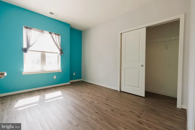 an empty room with wooden floor and closet