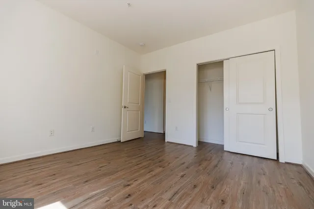 an empty room with wooden floor and closet