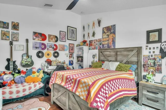 a bedroom with a bed and a lamp on a dresser