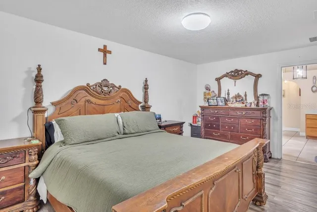 a bedroom with a bed and a painting on the wall