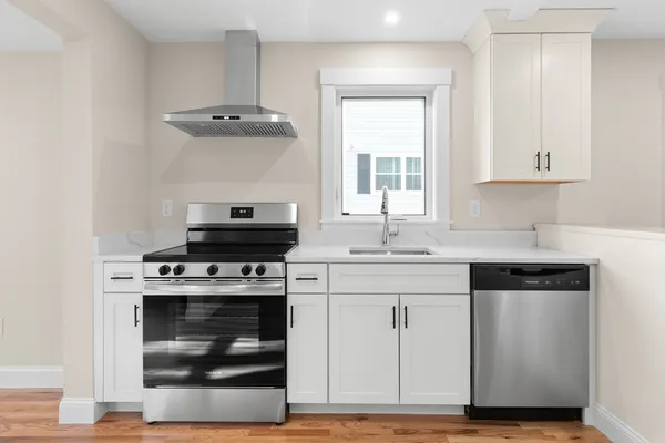 a kitchen with a stove and white cabinets
