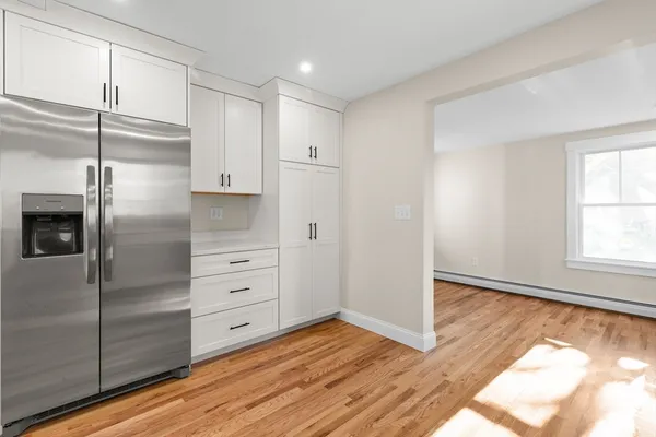 a kitchen with white cabinets and refrigerator