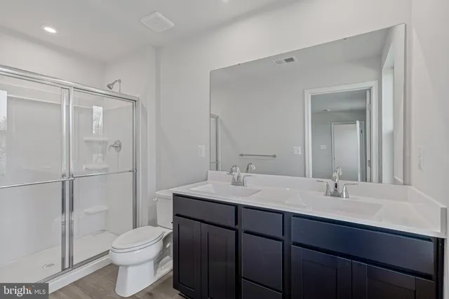 a bathroom with a toilet a sink a mirror and vanity