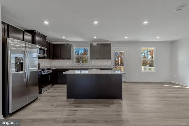 a large kitchen with stainless steel appliances granite countertop a stove a sink and a refrigerator