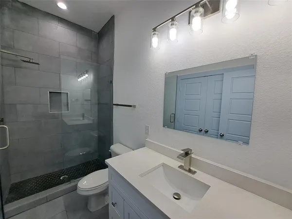 a bathroom with a sink a toilet and shower