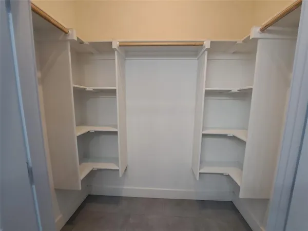 a view of walk in closet with empty racks