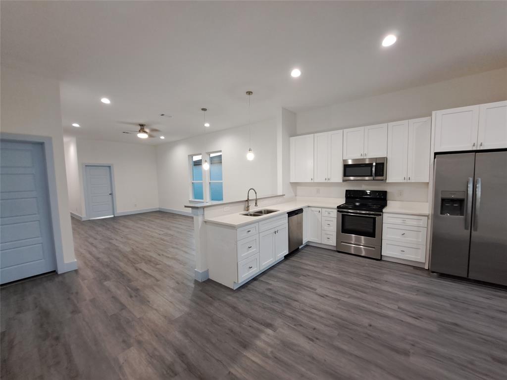 3235 Noor Street Dallas, TX 75233 - Photo 5 of 19 a large kitchen with a center island wooden floor stainless steel appliances and cabinets
