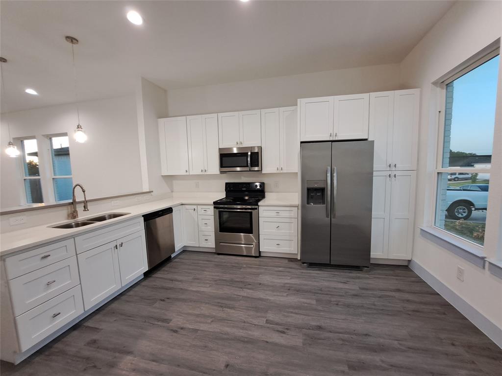 3235 Noor Street Dallas, TX 75233 - Photo 6 of 19 a large kitchen with a refrigerator a sink a stove top oven and cabinets