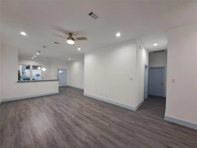 wooden floor in an empty room with a kitchen