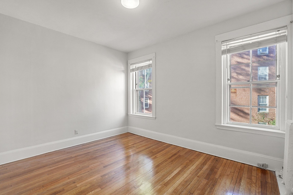 30 Kilsyth Road, Unit 3 Brookline, MA 02445 - Photo 7 of 11 a view of an empty room with wooden floor and a window