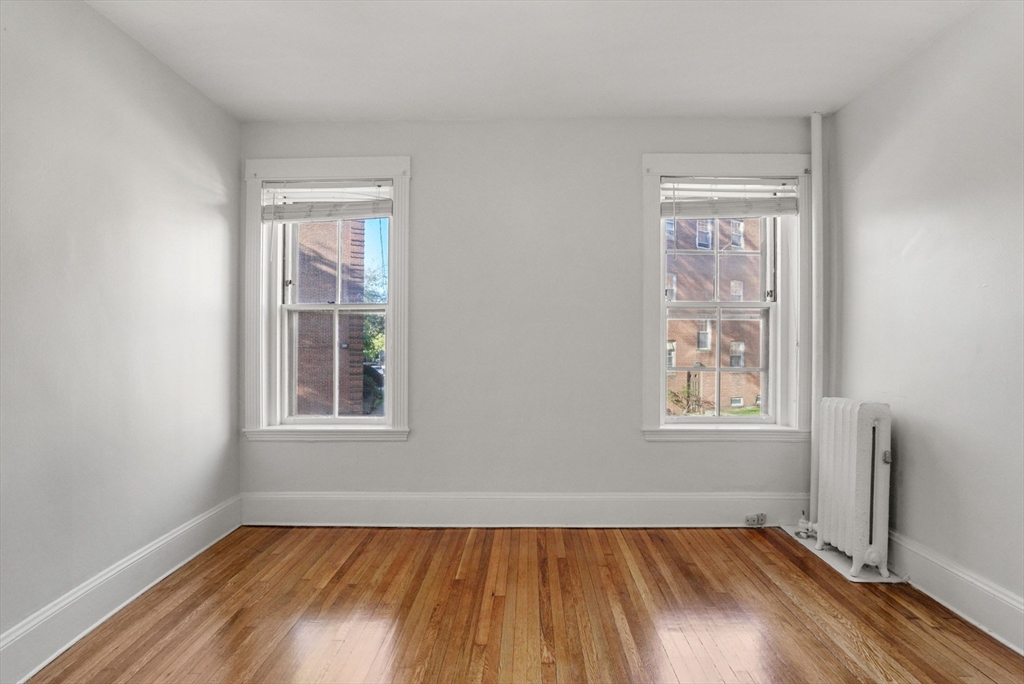 30 Kilsyth Road, Unit 3 Brookline, MA 02445 - Photo 8 of 11 an empty room with wooden floor and windows