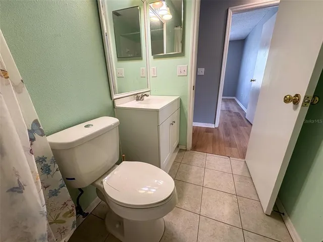 a white toilet sitting next to a bathroom sink and a mirror