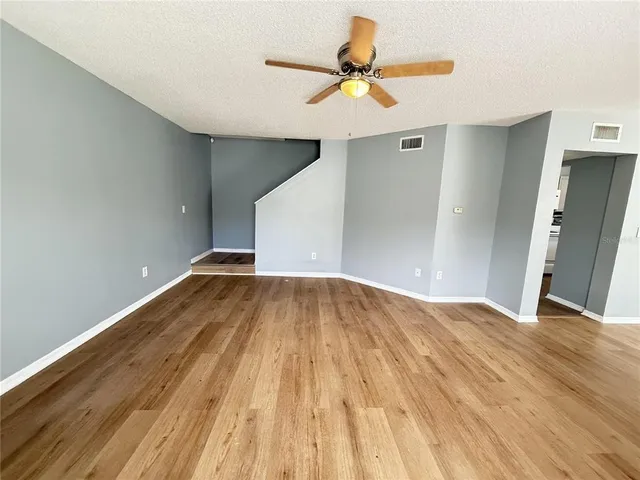 a view of empty room with wooden floor