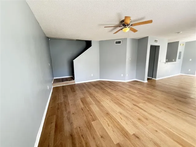 a view of a livingroom with wooden floor and a ceiling fan