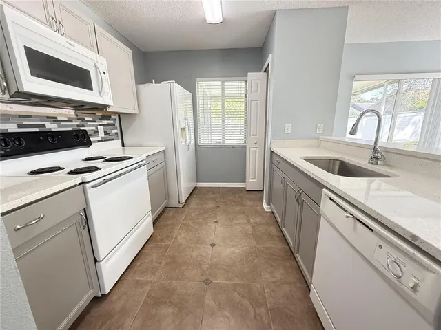 a kitchen with white cabinets and white appliances